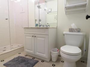 a white bathroom with a toilet and a shower at Driftwood Condo 15 in Cape May +13 photos
