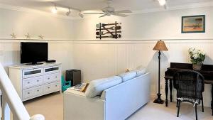 Una sala de estar con un sofá blanco y un televisor. en 707 E Lake Drive - Birds Eye View, en Cape May Point