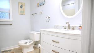 Un baño blanco con inodoro y espejo. en 707 E Lake Drive - Birds Eye View, en Cape May Point 28 fotos más