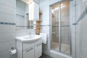 a white bathroom with a sink and a shower at Luxury Beach app P2 amazing location in Ivan Dolac +50 photos