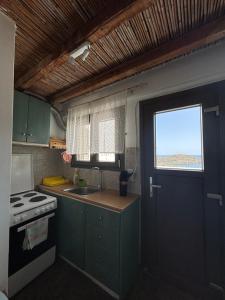 a kitchen with a sink and a stove and a door at The View Spot in Serifos Chora