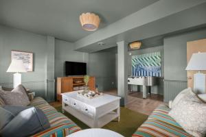 a living room with a couch and a table at Stylish Home with Pool Hot Tub & Walk to Beach in Duck