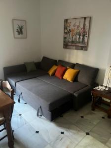 a gray couch with colorful pillows in a living room at Apartamento Centro Alfonso XII in Seville