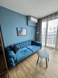 ein Wohnzimmer mit einem blauen Sofa und einem Tisch in der Unterkunft Sunrise l 1BD Sea View l Pool l Free Parking in Warna + 28 Fotos