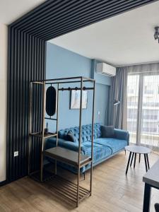 ein Schlafzimmer mit einem blauen Bett und einem Sofa in der Unterkunft Sunrise l 1BD Sea View l Pool l Free Parking in Warna