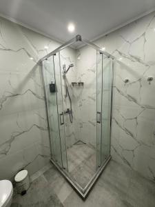 eine Duschkabine in einem Badezimmer mit Marmorwänden in der Unterkunft Sunrise l 1BD Sea View l Pool l Free Parking in Warna