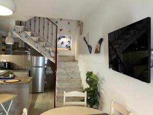 a living room with a staircase with a tv on the wall at Casa das Andorinhas in Lagos
