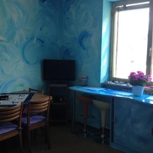 a blue room with a table and a television at Alloggio azzurro CIR Aosta 0099 in Aosta