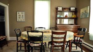 una sala da pranzo con tavolo e alcune sedie di The Windsor Cottage a Cape May