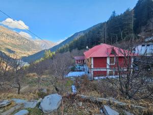 JāmbにあるHimalaya Vistaの山の上にある赤い屋根の赤い家