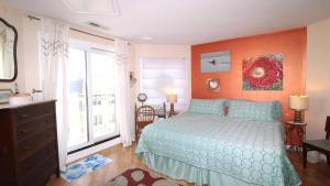 Un dormitorio con una cama azul con una pared naranja. en Capers302, en Cape May