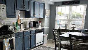 une cuisine avec des armoires bleues et une table avec un tableablish dans l'établissement Cape Island Creekview, à Cape May