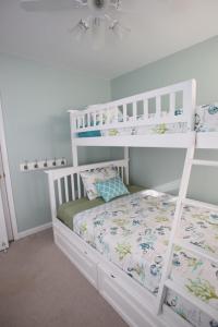 Ce lit superposé blanc se trouve dans une chambre blanche. dans l'établissement Cape Island Creekview, à Cape May