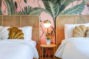 a bedroom with two beds and a wall with plants at Le Particulier Miami in Miami Beach