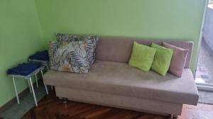 a couch with pillows on it in a living room at Apartment Medika 2 in Ruse