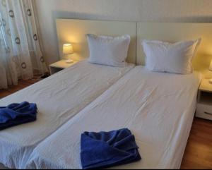 a white bed with two towels on top of it at Apartment Medika 2 in Ruse