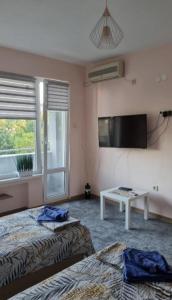 Una habitación de hotel con dos camas y un televisor. en Apartment Medika 2, en Ruse