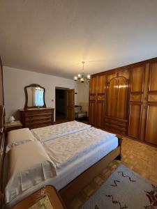 a bedroom with a large bed and wooden cabinets at Appartamento di Nina in Moena