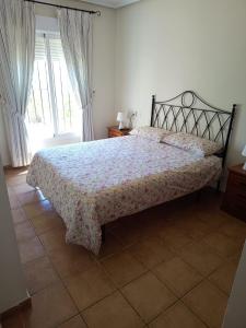 a bedroom with a bed with a floral bedspread at Bonito y cómodo apartamento in Vera