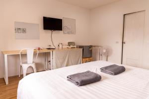 a bedroom with a bed with two towels on it at Jida Place in Chiang Mai