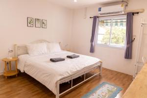 a bedroom with a bed with two bags on it at Jida Place in Chiang Mai