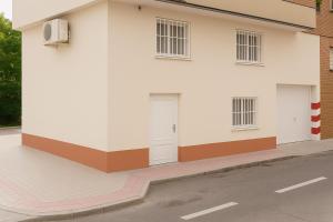 a white building with a door on the side of it at Hospedaje La Campana in Madrid