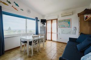 a living room with a table and a blue couch at Stintino sardegna delizioso bilocale vista mare in Stintino