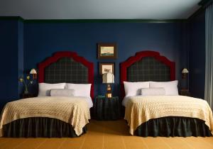 two beds in a room with blue walls at Portrush Adelphi in Portrush