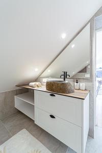 a bathroom with a sink and a white counter at Symphony Apartment with free parking in Kaunas