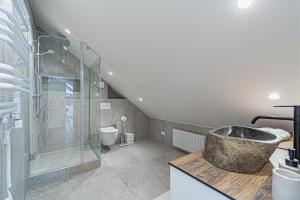 a bathroom with a sink and a glass shower at Symphony Apartment with free parking in Kaunas +22 photos