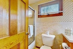 a small bathroom with a toilet and a window at Cape Beach Bungalow in Dennis Port +11 photos
