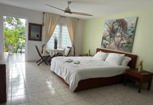 a bedroom with a bed with a painting on the wall at Newly renovated studio in Simpson Bay