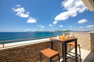 a table and two chairs on a balcony overlooking the ocean at ForRest Seaside Loft View 121 in Alghero
