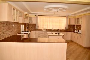 a large kitchen with white cabinets and a sink at Olives and Roses in Eldoret