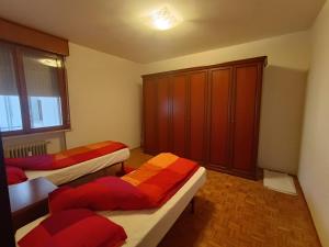 a bedroom with two beds and a cabinet at Appartamento Confine in Concordia Sagittaria