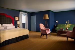 a bedroom with a bed and a chair and a desk at Portrush Adelphi in Portrush