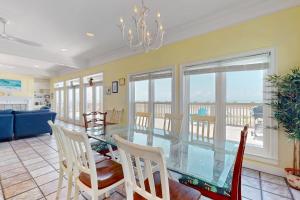 Un comedor con una mesa de cristal y sillas. en Island Sunrise, en Dauphin Island