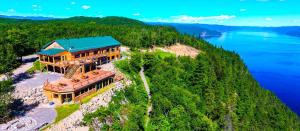 北圣罗斯Auberge Cap au Leste的水边山丘上房屋的鸟瞰图