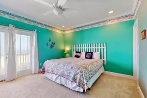 Un dormitorio con una cama y una pared verde. en Island Sunrise, en Dauphin Island 18 fotos más