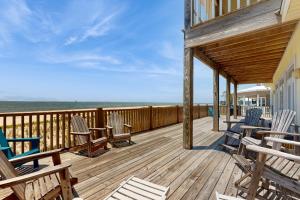 una terraza con sillas y mesas y el océano en Island Sunrise, en Dauphin Island