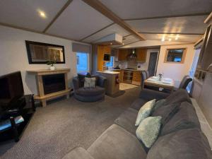 a living room with a couch and a fireplace at Marsh Farm Holiday Park in Great Yarmouth