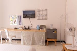 a room with a desk with a tv on the wall at Jida Place in Chiang Mai