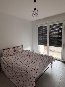 カップ・ダグドにあるAppartement 6 personnes Cap d'Agdeの赤い掛け布団が敷かれたベッドのある寝室