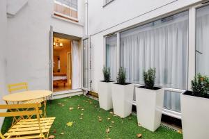 a balcony with a table and potted plants at Residences at The Gyle - London in London