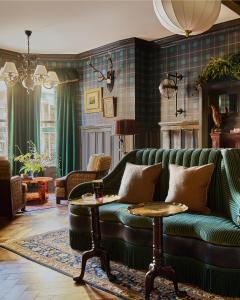 a living room with a green couch and a table at Portrush Adelphi in Portrush