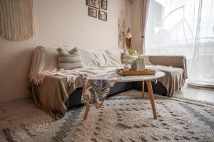 a living room with a couch and a table at Boho Apartment Plovdiv with Private Parking Space in Plovdiv