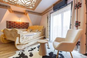 a bedroom with a bed and a chair and a window at Kilimy in Poronin +22 photos