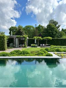 a swimming pool in the middle of a garden at Lit de Clémot in Merelbeke