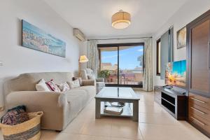 a living room with a couch and a tv at Pilar Luxury Apartment in Benalmádena