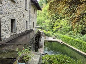 a building next to a river next to a building at Molino Valsecchi 1369 in Asso